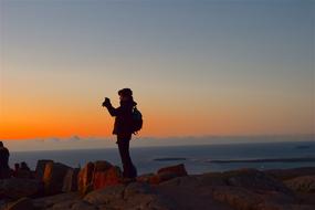 human on the rocks against a backdrop of sunsets