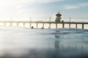 long bridge with a lighthouse on the sea