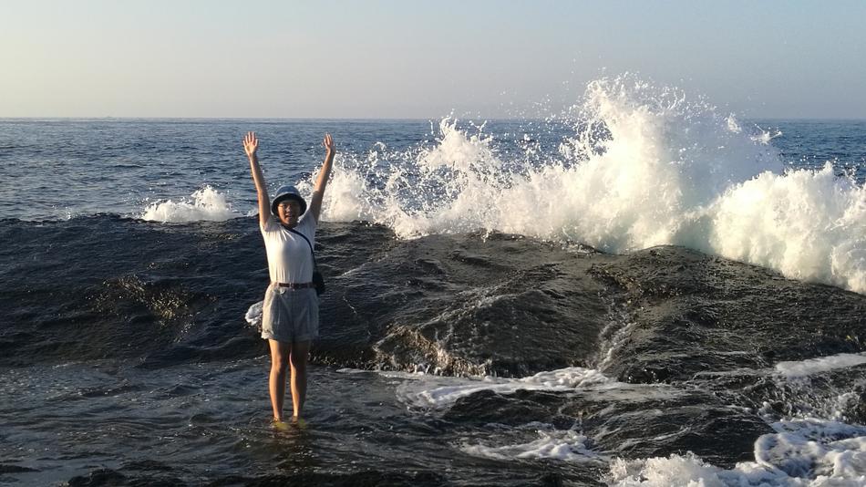 Girl on the waves on the rocks