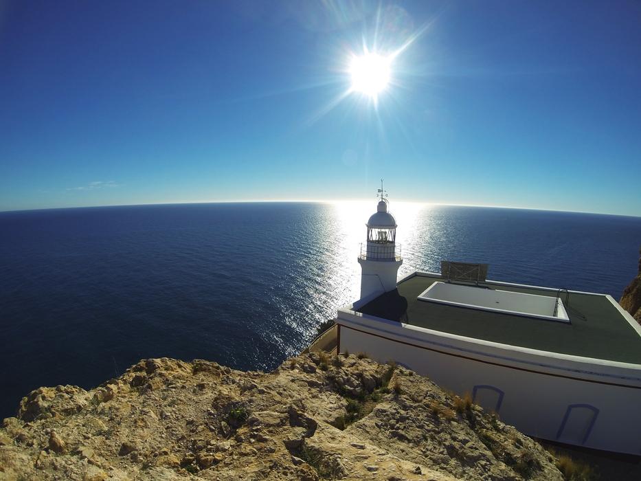white lighthouse in the sun by the sea