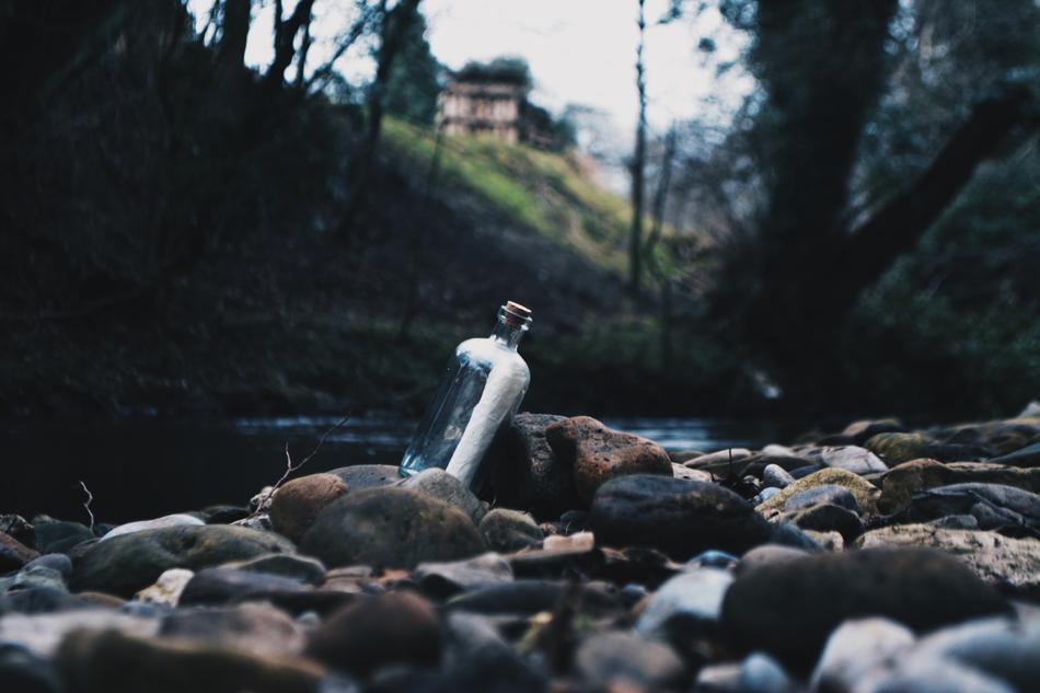 forgotten bottle in the rocks by the lake