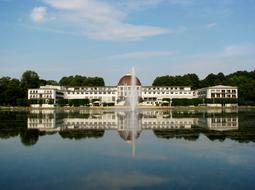 white house with a fountain by the lake