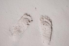 human footprints on white sand