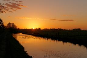 scenic Sunset, calm River beneath golden Evening Sky