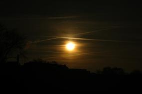 Contrails in dark sky at Sunset
