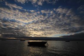Boat anchored near coast at dusk