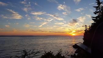 sun setting over water at horizon