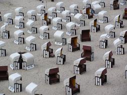 rows of Canopy Chairs on grey sand Beach