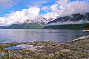 wild rocky coast at calm sea, Norway, hardangerfjord
