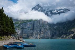 boats in bay near scenic Mountain with clouds on peak