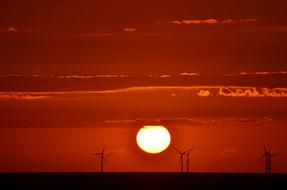 Orange sunset against a background of windmills