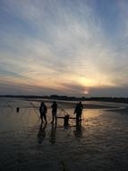 three Fishermen on Beach at Sunset, uk, england, sussex