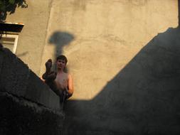 young barefoot man sits at wall