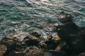 turquoise Sea at dark rocks
