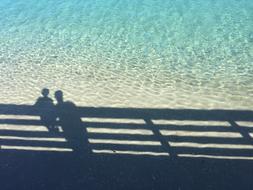 man and child at fence shadow on Sea