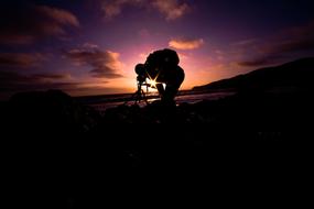 Silhouette of a man on a bicycle lit by the sun