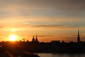 sun silhouette city clouds