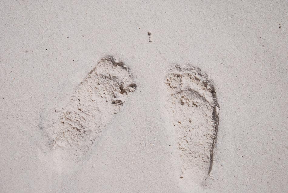 human footprints on white sand