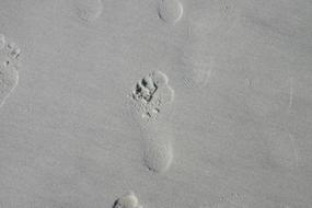 human Footprints on grey Sand