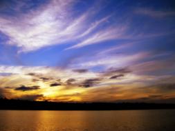 colorful dramatic sky over calm water at sunset