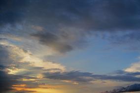 white, golden and dark Clouds in evening sky