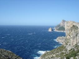 blue sea with mountains in the clouds