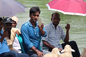 asian men group with Umbrella in Boat