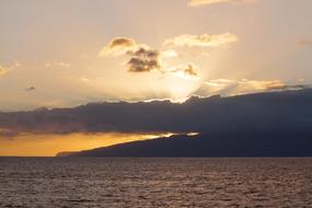 Sun bursting through dark Clouds over sea beach