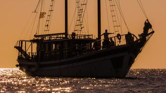 people on Sailboat in Sea at Sunset