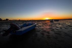 boat on the beach at sunset