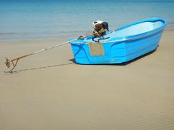 blue boat on a sandy beach