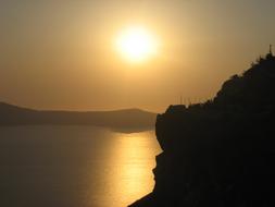 sun silhouetted on an island