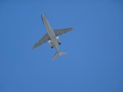 a white plane in the blue sky