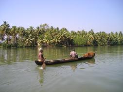 two Fishermen in rowing Boat on green river, India