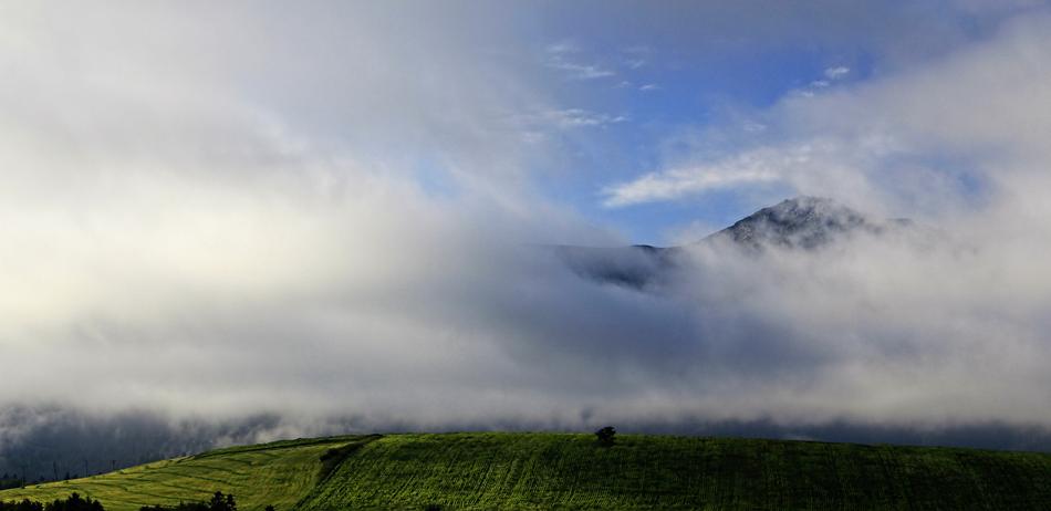 green mountain with clouds