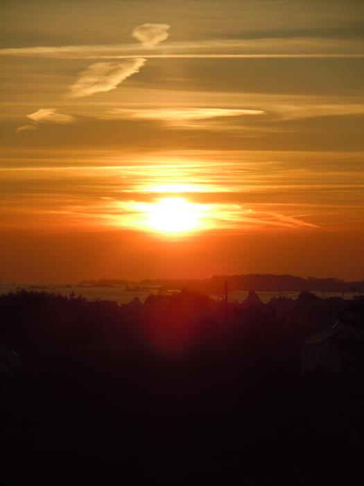 sunset over the silhouette of a hill
