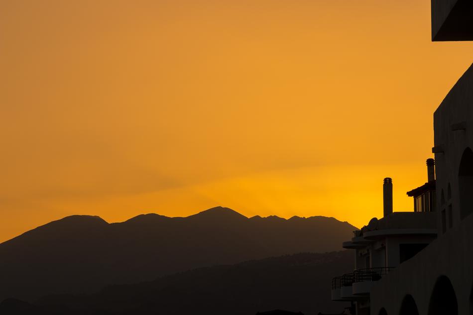 beautiful sunset with the mountains by the city