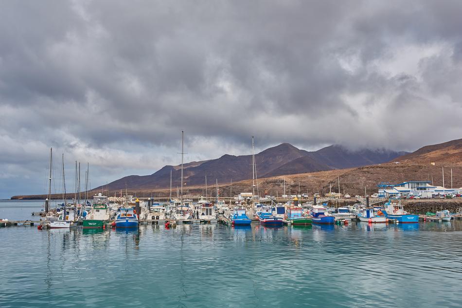 clouds mountains pier boats