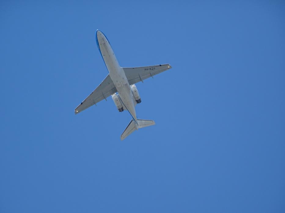a white plane in the blue sky