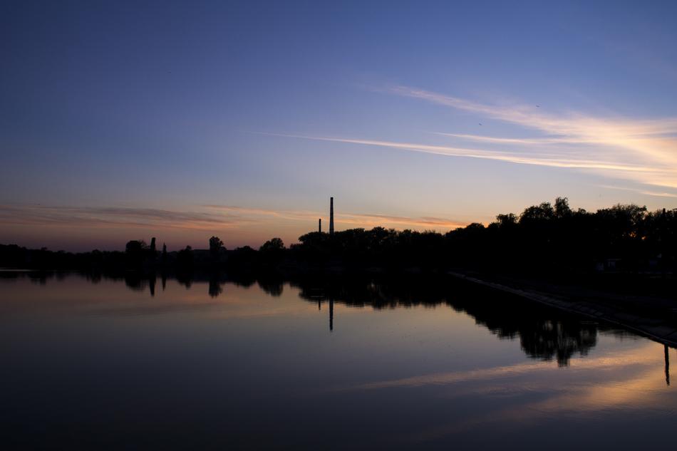the silhouette of the trees by the lake