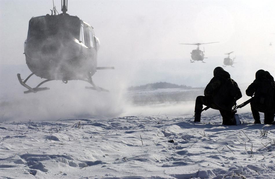 Soldiers on the snow near the helicopters