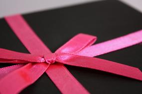 macro photo of a pink ribbon on a gift