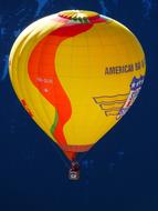 yellow hot air balloon on a background of mountains