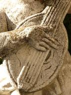 person plays mandolin, stone sculpture, detail