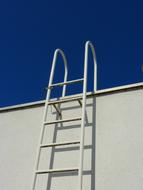 white ladder on wall at sky