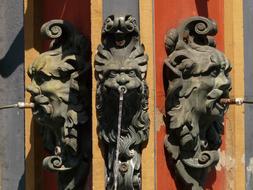 three symmetrical metal statues of the middle ages close-up