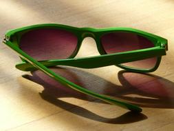 green sunglasses on wood table