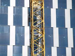 yellow crane tower at blue and white facade