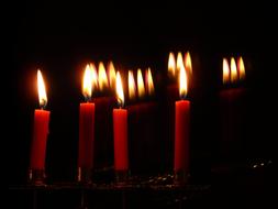 red candles burn in the dark