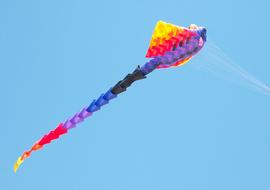 long colorful kite in the blue sky